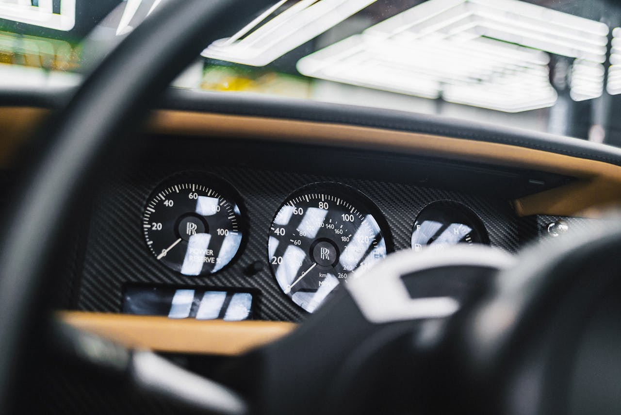 Detailed interior view of a Rolls Royce dashboard featuring speedometer and dials.