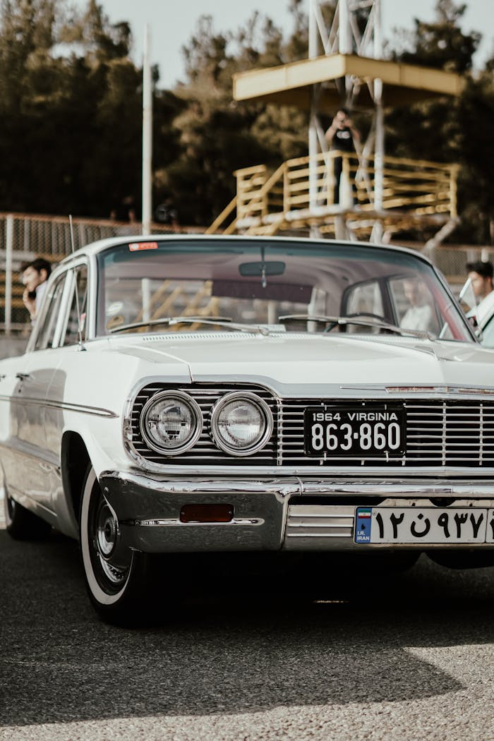Front view of a vintage 1964 Chevrolet with Virginia and foreign plates, outdoors.